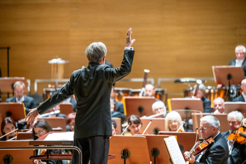 Dyrygent Paweł Przytocki podczas koncertu na zakończenie sezonu