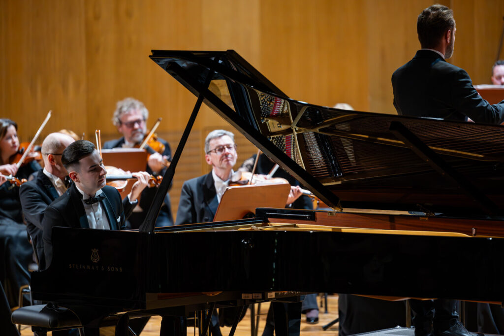 Dominik Gilewski (fortepian) i Orkiestra Symfoniczna Filharmonii Podkarpackiej pod batutą Piotra Kościka, w czasie koncertu symfonicznego