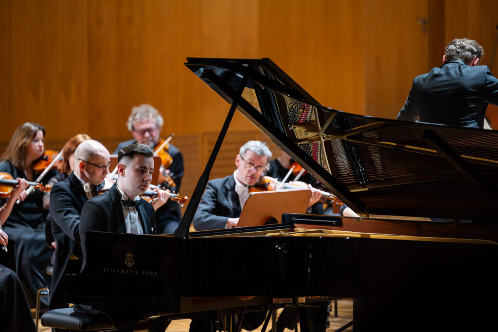 Dominik Gilewski (fortepian) i Orkiestra Symfoniczna Filharmonii Podkarpackiej pod batutą Piotra Kościka, w czasie koncertu symfonicznego