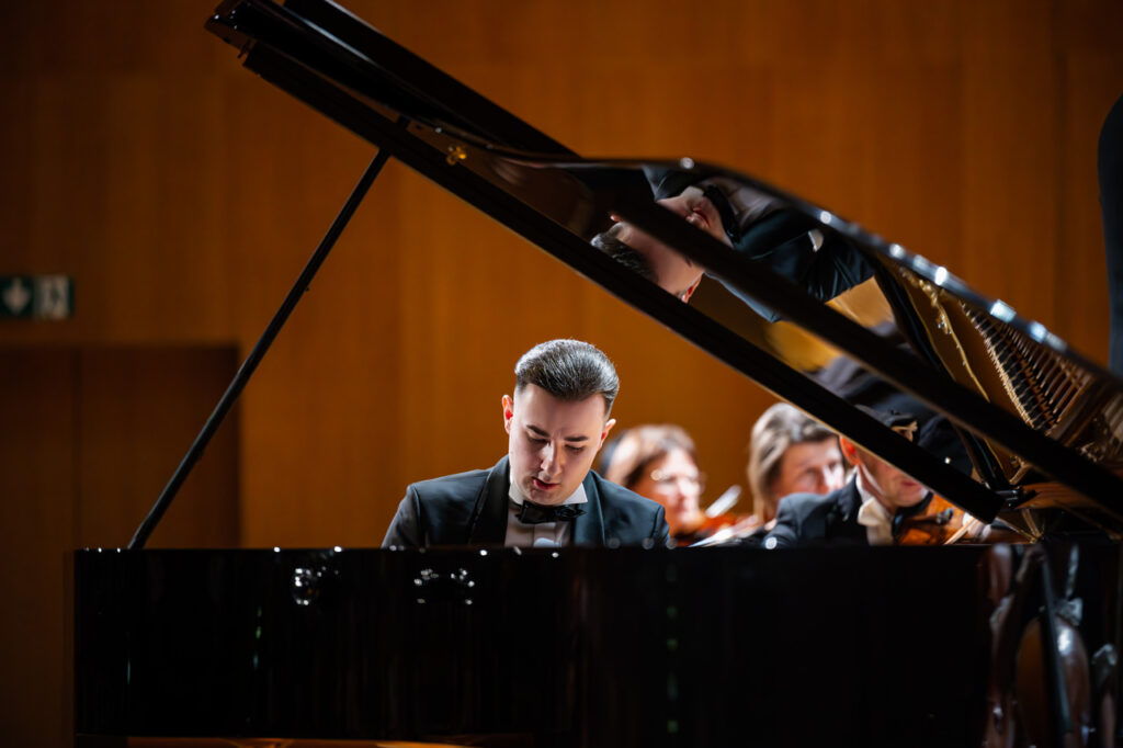 Dominik Gilewski (fortepian) i Orkiestra Symfoniczna Filharmonii Podkarpackiej pod batutą Piotra Kościka, w czasie koncertu symfonicznego