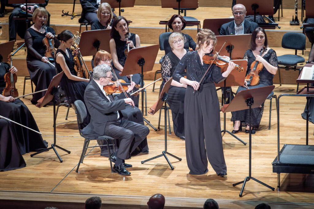 Anna Gutowska (skrzypce) i Orkiestra Symfoniczna Filharmonii Podkarpackiej pod batutą Marka Pijarowskiego, w czasie koncertu symfonicznego