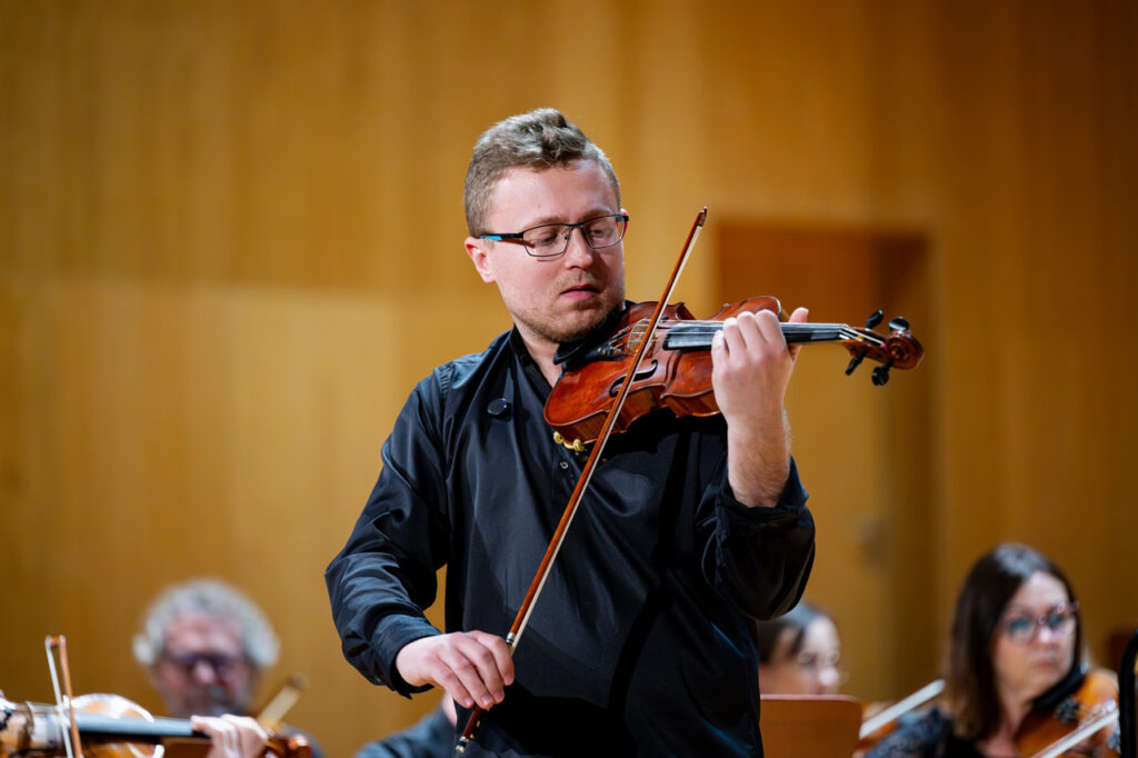 Szymon Tadla (skrzypce) i Orkiestra Symfoniczna Filharmonii Podkarpackiej pod batutą Krzysztofa Kozakiewicza, w czasie koncertu szkolnego