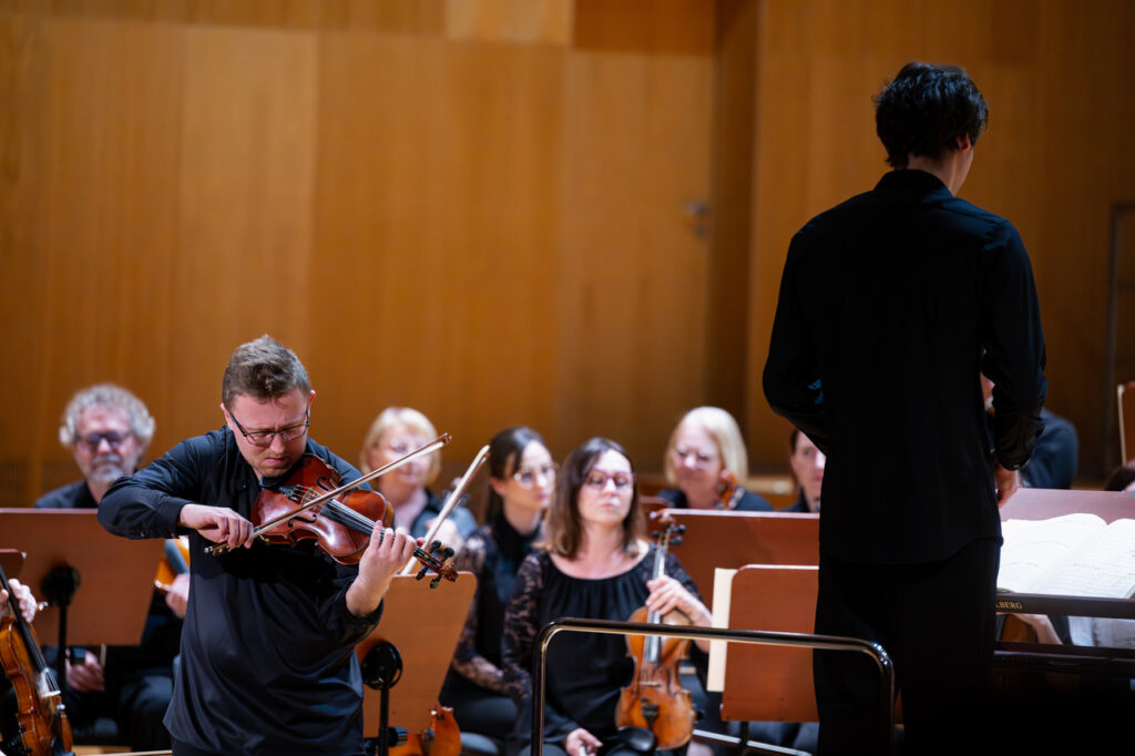 Szymon Tadla (skrzypce) i Orkiestra Symfoniczna Filharmonii Podkarpackiej pod batutą Krzysztofa Kozakiewicza, w czasie koncertu szkolnego